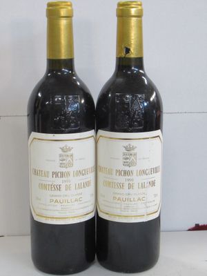 two bottles of wine sitting next to each other on a table
