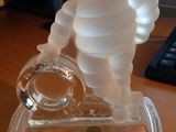 une figurine en verre représentant un homme, posée sur un bureau