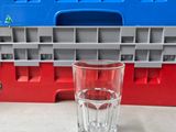 un verre d'eau posé sur un plan de travail à côté d'un récipient en plastique