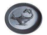 a black and white photo of a plate with a bird on it
