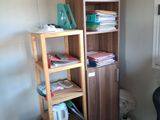 a desk with a chair and a book shelf in the corner