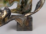 a statue of a cat sitting on a tree branch