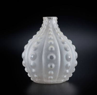 un gros plan d'un vase blanc posé sur une surface noire