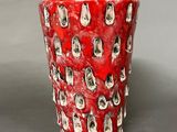 a red cup with a pattern of cats on it