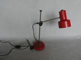 a red table lamp that is on a table
