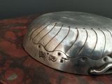 a silver plate with a whale on it sitting on a table