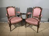 two red and white striped chairs sitting next to each other on a tiled floor