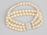 un gros plan sur un collier de perles blanches muni d'un fermoir