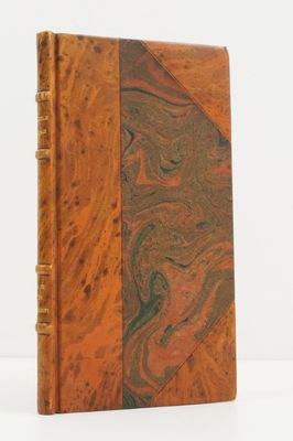 an old book with a marbled cover on a white surface