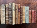 several old books are lined up in a row on a table