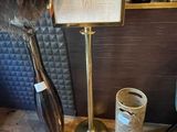 a vase with a feather on it next to a sign