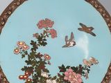 a blue plate with flowers and birds on it