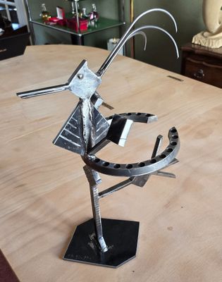 une sculpture métallique représentant un oiseau, posée sur une table
