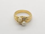 a close up of a gold ring with two pearls on it