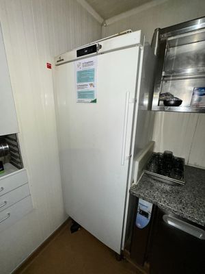 a white refrigerator in a small kitchen with a sink and dishwasher