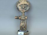figurine représentant un homme avec une croix sur la tête