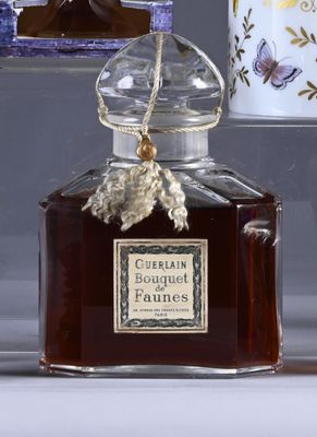 a bottle of perfume sitting on a table next to a cup