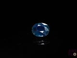 a close up of a blue sapphire stone on a black surface