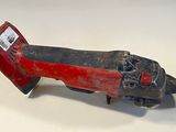 an old red and black tool on a white surface