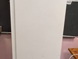 un réfrigérateur blanc dans une cuisine rose, avec un tableau noir accroché au mur