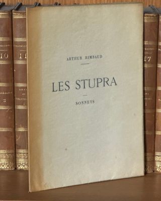 un livre posé sur une étagère à côté d'une pile de livres