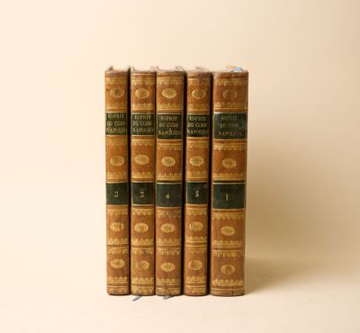 trois vieux livres posés l'un sur l'autre sur une surface blanche