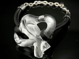 un bracelet en cuir noir orné d'un cœur en verre transparent