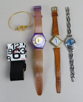 trois montres et un bracelet de montre posés sur une table