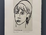 un dessin en noir et blanc représentant le visage d'une femme, accroché au mur