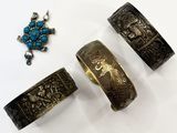 three pieces of silver and turquoise jewelry sitting on a white surface