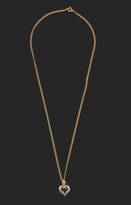 un collier en or avec un pendentif en forme de cœur sur une chaîne