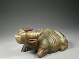 un gros plan sur une statue de taureau posée sur une surface grise