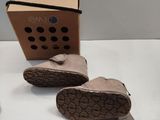 the pair of shoes are next to a cardboard box on the table