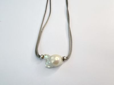 collier composé d'une perle blanche et d'une chaîne en argent, sur un fond blanc
