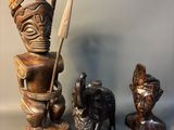 three wooden statues of a man and a woman and a dog