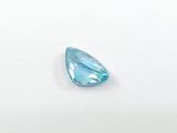 a blue topazte tear shaped stone on a white surface