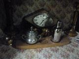 une table sur laquelle se trouvent une horloge et de l'argenterie