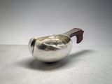 a silver teapot with a wooden handle on a table