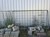 a pile of bricks sitting in front of a fence