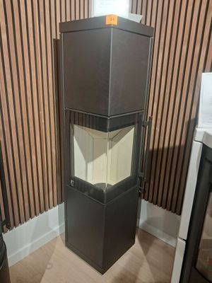 une armoire noire avec une porte vitrée, dans un coin de la pièce