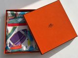 an orange box with a pair of socks in it on a white surface