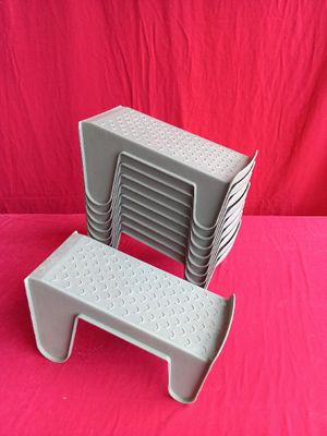 a stack of plastic chairs on a pink surface