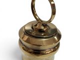 an image of a gold ring on top of a brass container