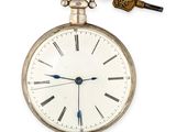 une montre de poche en argent à laquelle est accrochée une clé, suspendue à sa chaîne