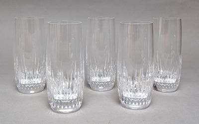 four clear glasses are lined up in a row on a white surface
