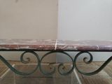 a marble table with a metal base in a room