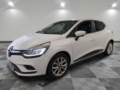 une voiture blanche est garée dans une pièce au sol à carreaux