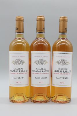 trois bouteilles de vin posées les unes à côté des autres sur une surface blanche