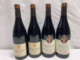 three bottles of red wine are lined up on a table
