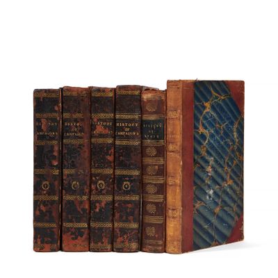 plusieurs vieux livres sont empilés sur une surface blanche